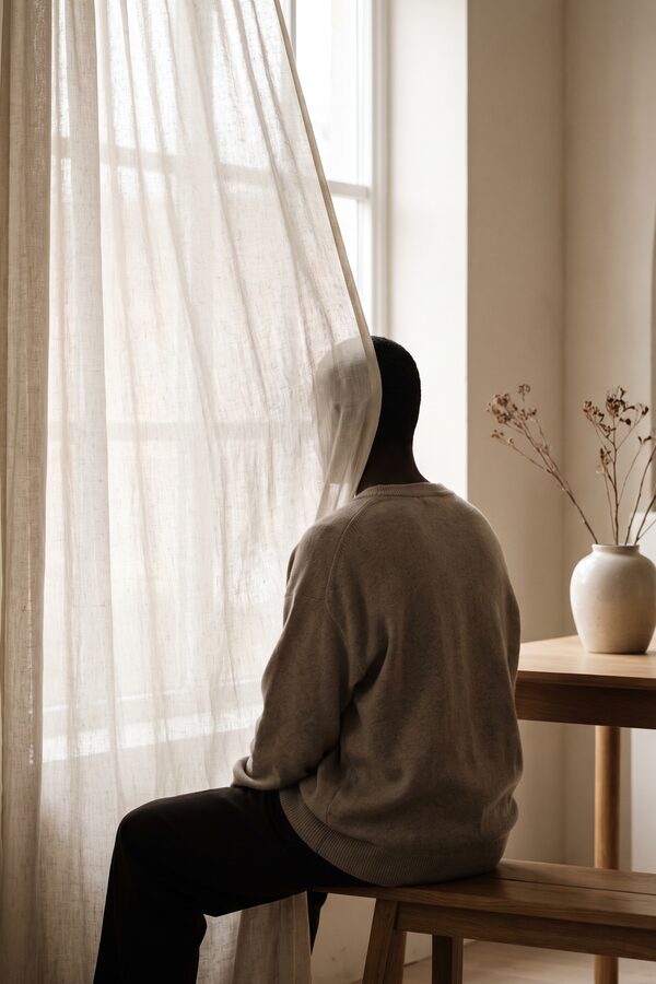 시어커튼 창가에 선 인물의 뒷모습 실루엣 — 이목구비가 드러나지 않는 비식별 분위기 컷