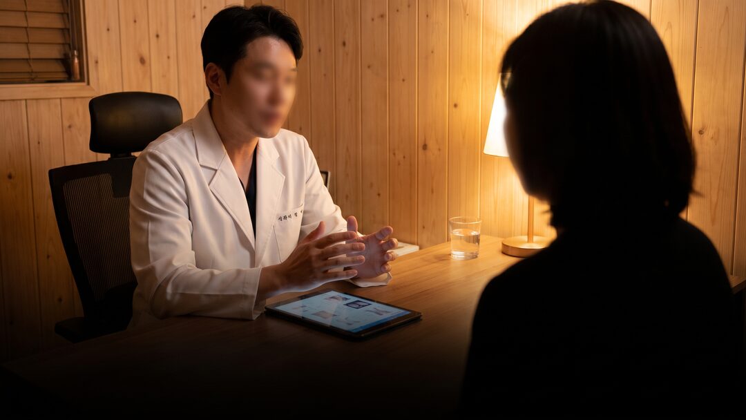 상담실에서 내담자와 마주 앉아 설명하는 의료진