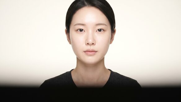 눈밑지방재배치 안내 포스터 — 정면을 응시하는 여성 모델의 얼굴 클로즈업