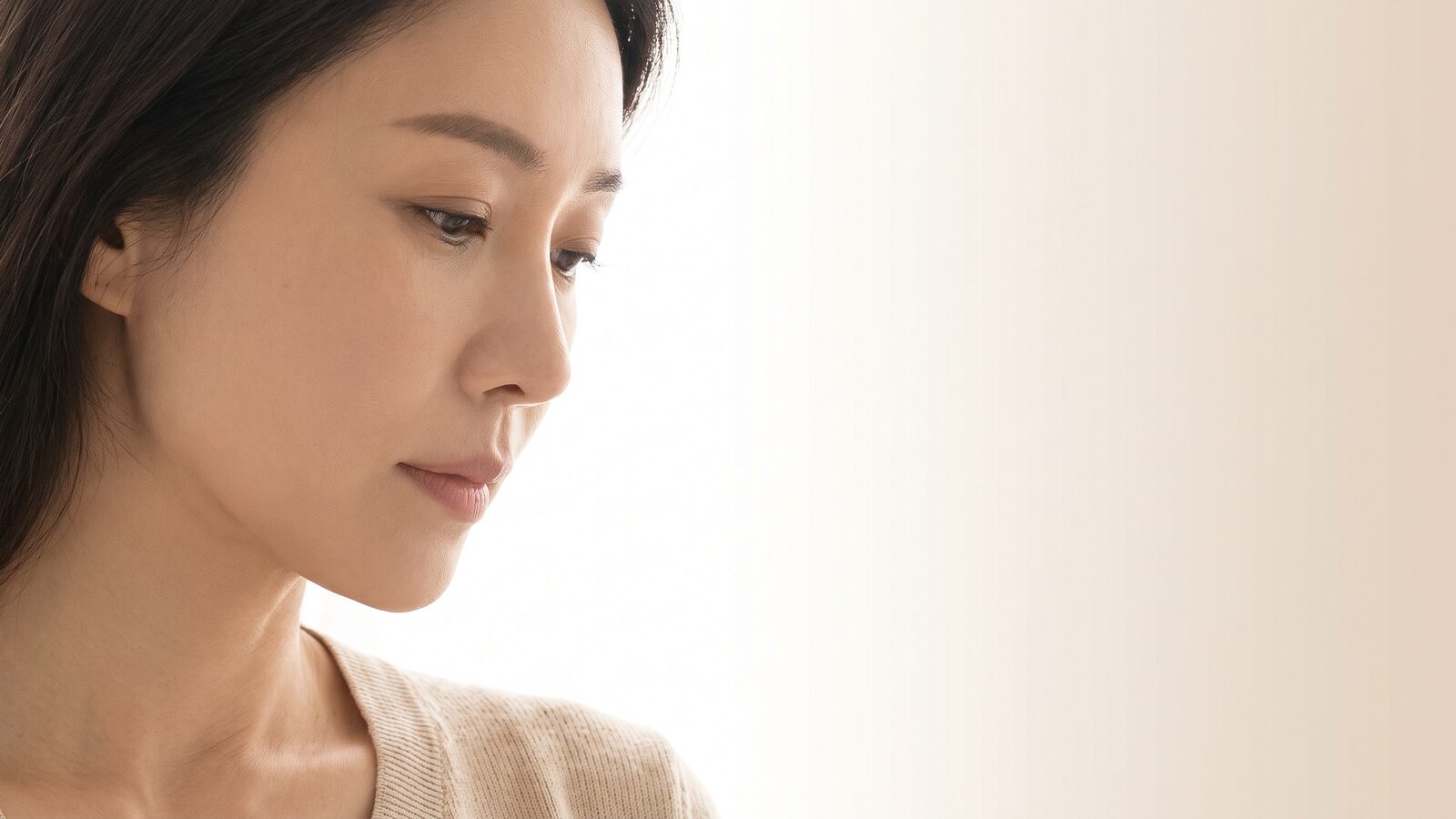 반측면으로 시선을 내린 여성 모델의 상반신 컷