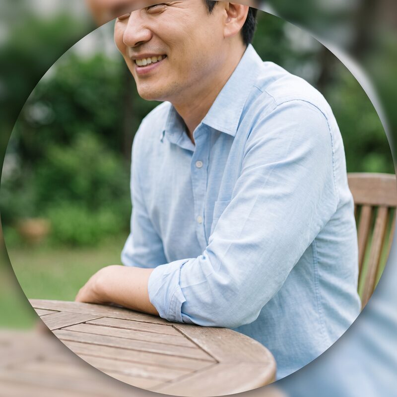정원 테이블에 기대어 편안하게 웃는 이웃의 모습