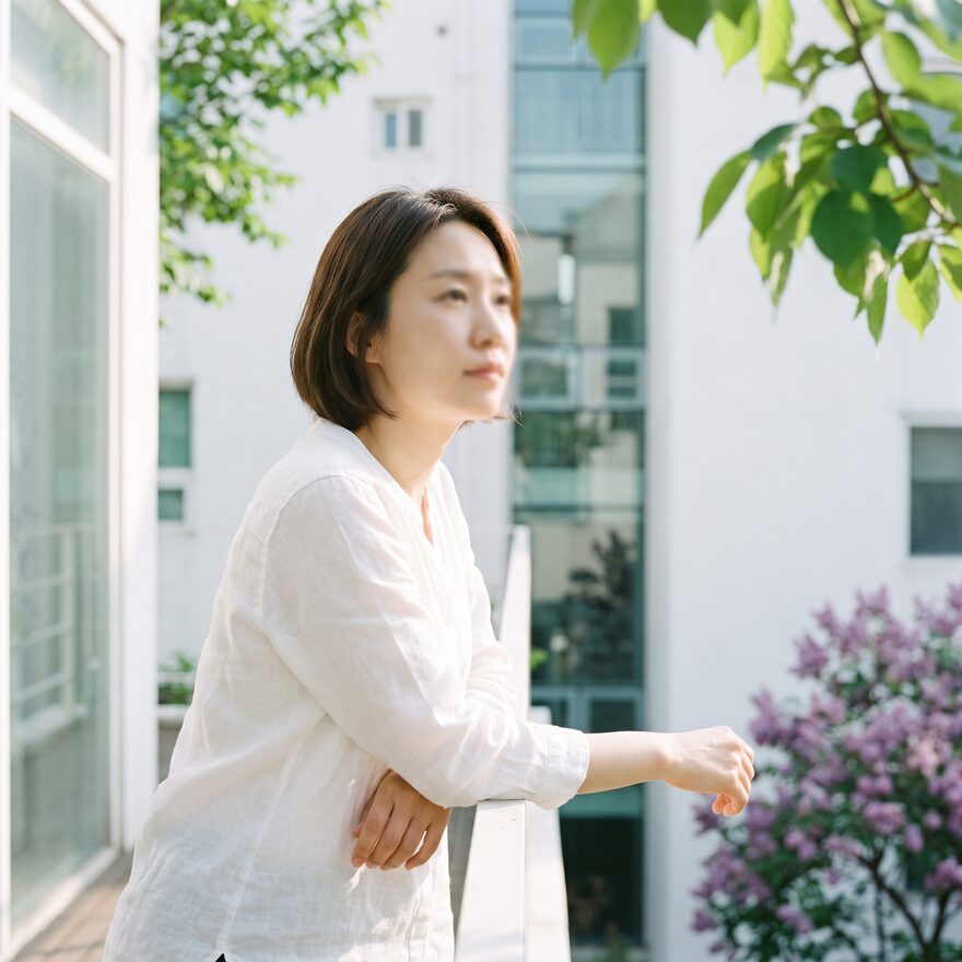 야외 난간에 기대어 선 리뷰티 웰케어 담당 원장