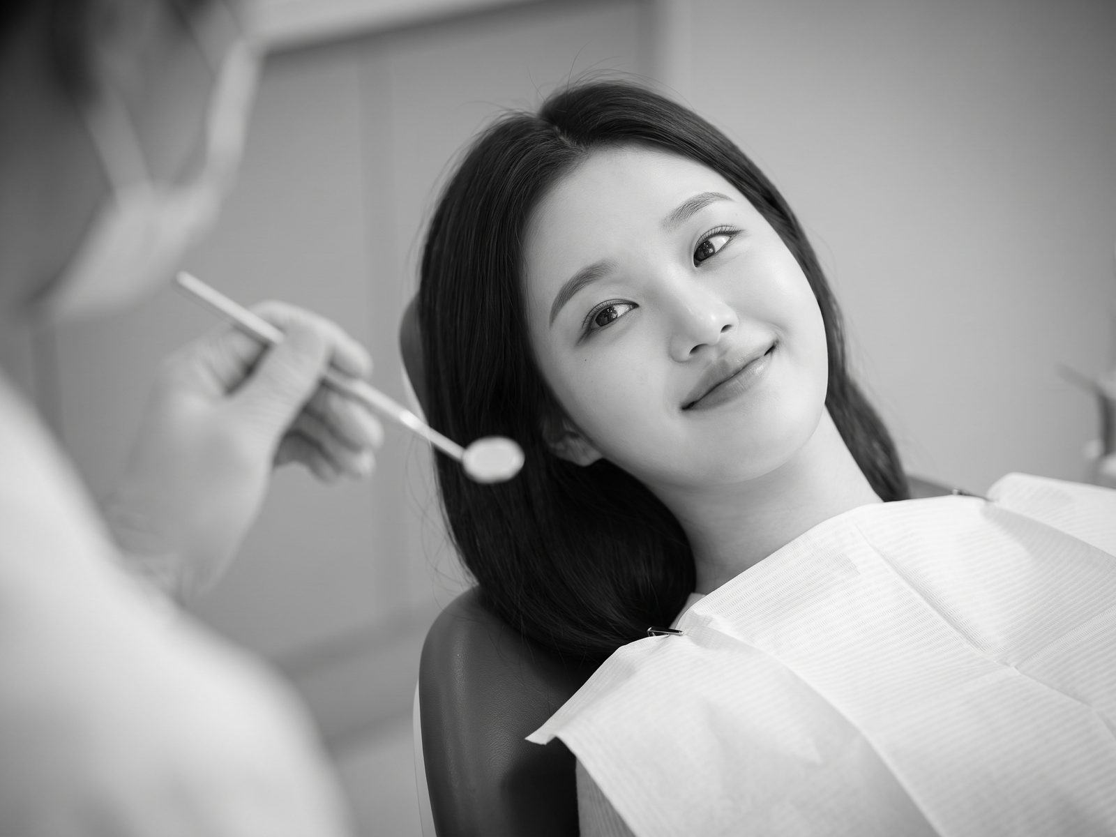 진료 의자에 편안히 기대어 미소 짓는 가상 모델의 흑백 사진 (AI 생성 예시 이미지)