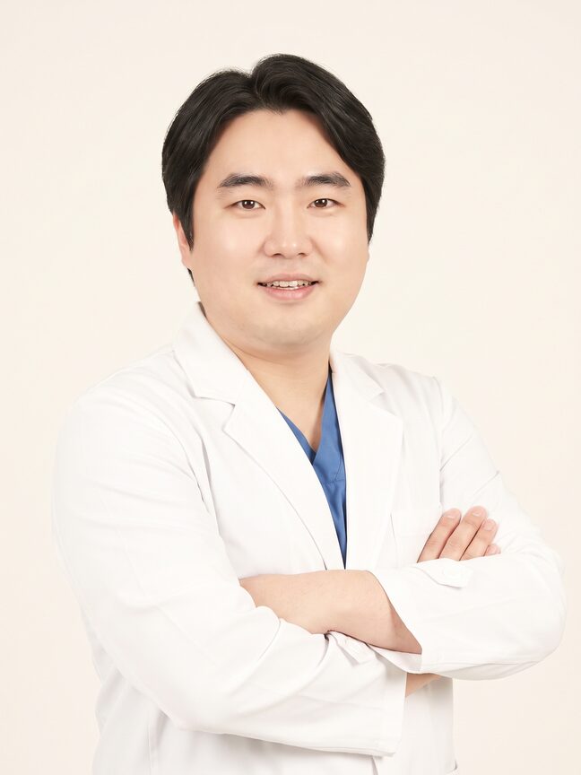 흰 가운을 스크럽 위에 걸친 남성 가상 의료진 모델 상반신 인물 컷 (AI 생성 예시 이미지)