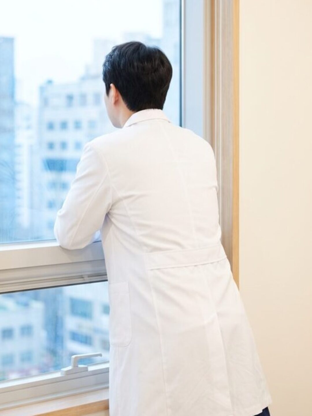테라스 난간에 기대어 정원을 바라보는 리뷰티 웰니스 클리닉 원장