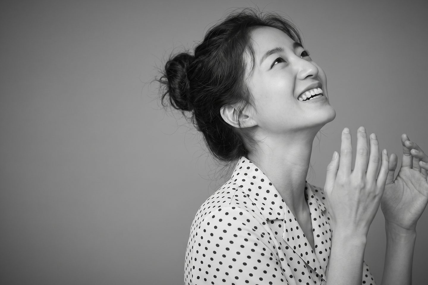 차분한 회색 배경 앞에서 고개를 살짝 기울인 리뷰티 가상 모델의 눈매 중심 뷰티 포트레이트