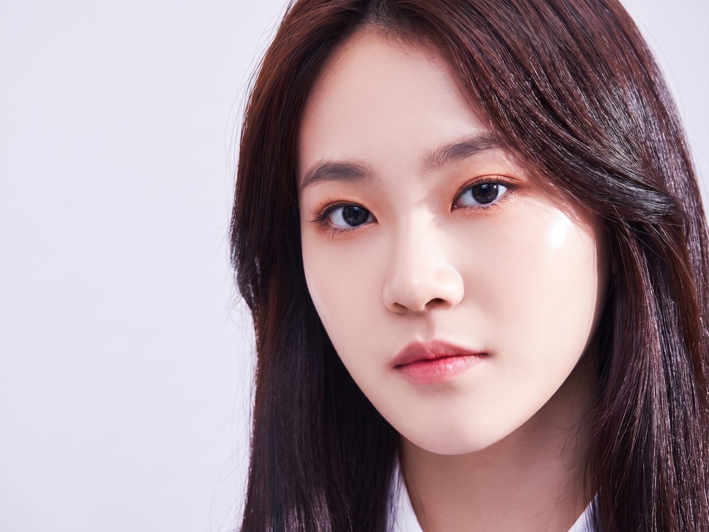 차분한 회색 배경 앞에서 고개를 살짝 기울인 리뷰티 가상 모델의 눈매 중심 뷰티 포트레이트