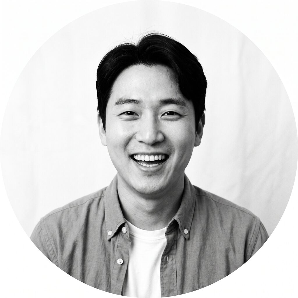 셔츠 위에 흰 티를 받쳐 입은 남성 모델이 환하게 웃는 흑백 상반신 예시 이미지