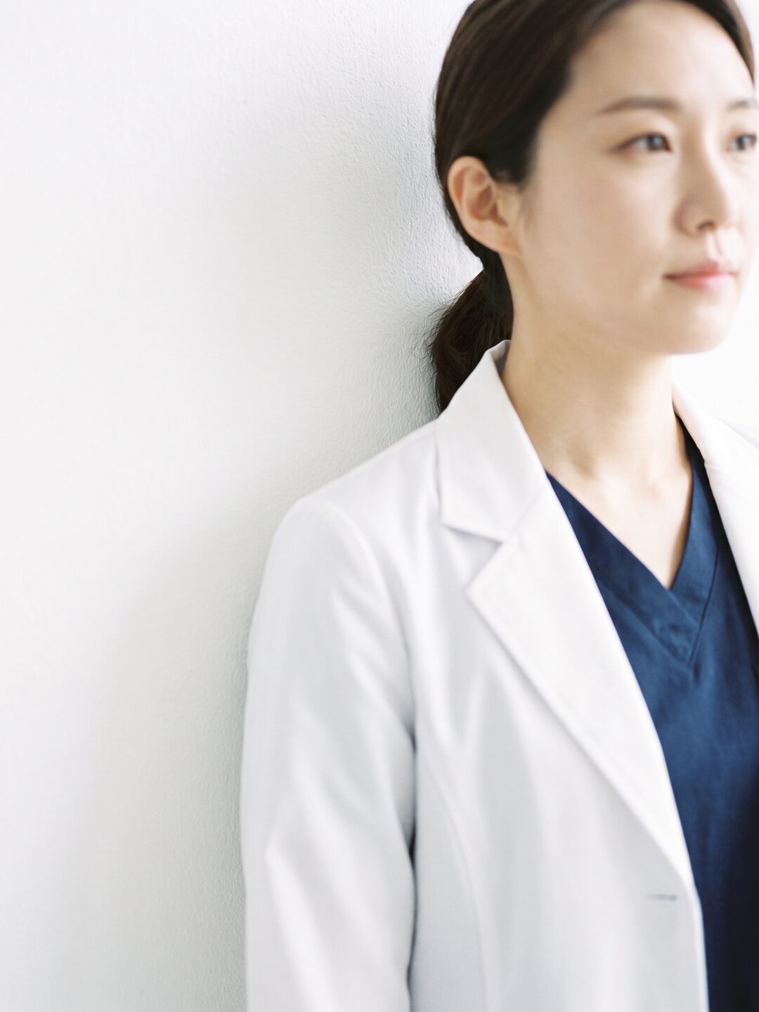 밝은 흰 벽에 기대선 리뷰티 웰에이징 FACE 진료원장을 표현한 AI 생성 예시 이미지