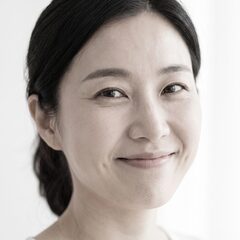 머리를 묶고 밝게 웃는 여성 모델의 얼굴 클로즈업