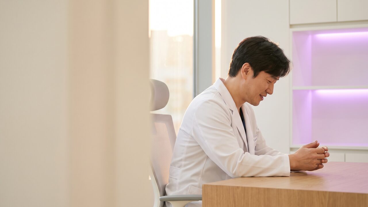 상담 데스크에 앉은 리뷰티 의료진이 눈매 상담 내용을 정리하는 모습 (AI 생성 예시 이미지)