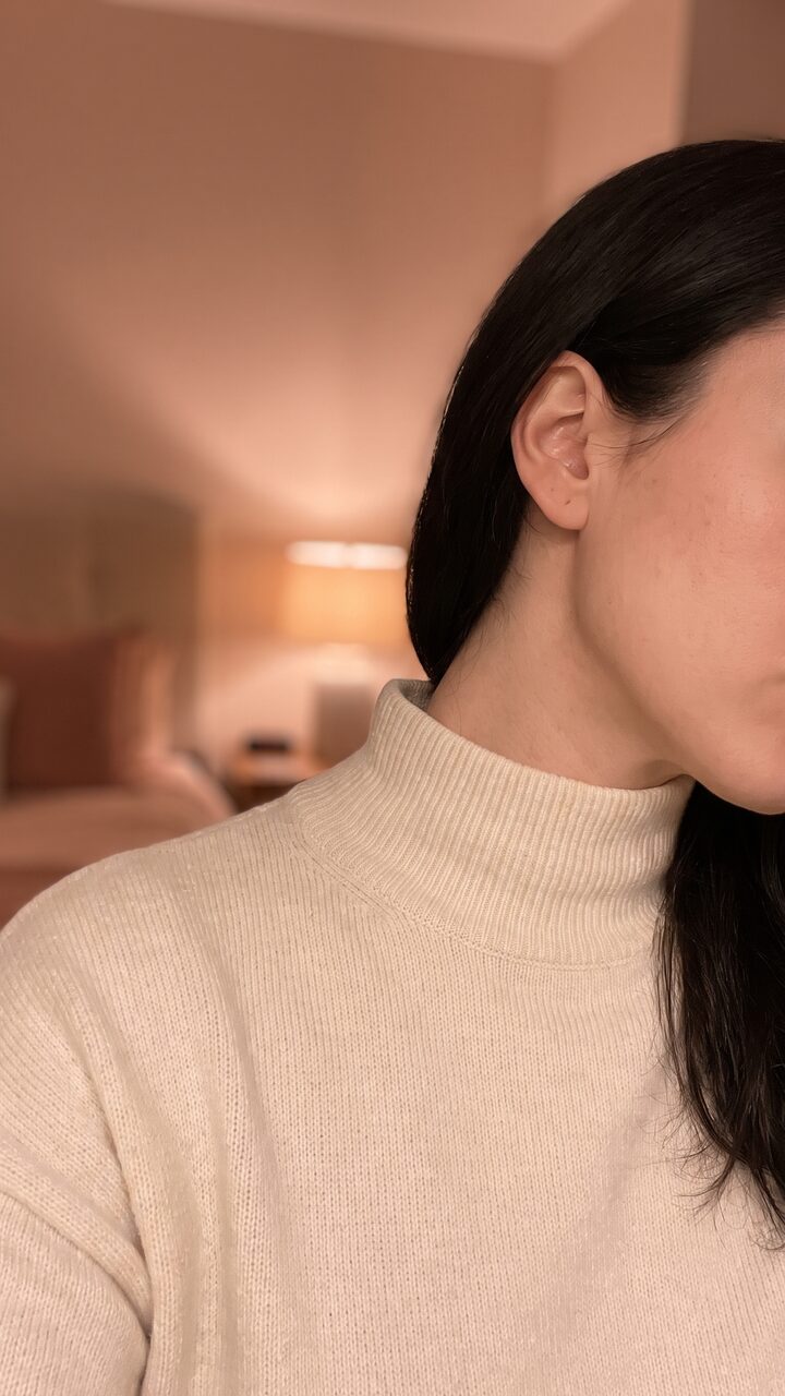 따뜻한 실내광에서 목선을 세워 옆을 본 가상 모델의 세로 숏폼 예시 컷