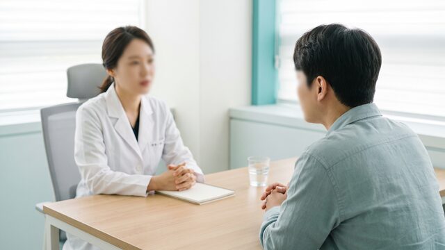 남성 방문자가 코 라인 상담을 받는 오버숄더 구도의 영상 예시 컷