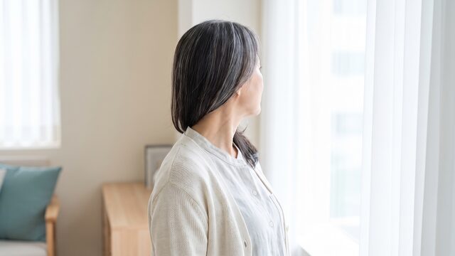 창가에서 측면으로 서 있는 중년 모델의 라이프스타일 영상 예시 컷