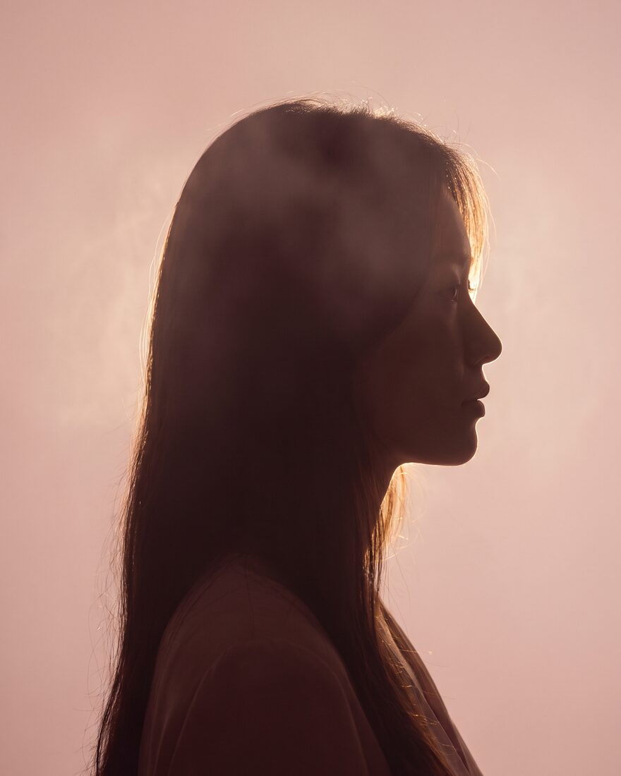 블러시 핑크 배경의 역광 실루엣 옆모습 무드 컷 (AI 생성 예시 이미지)